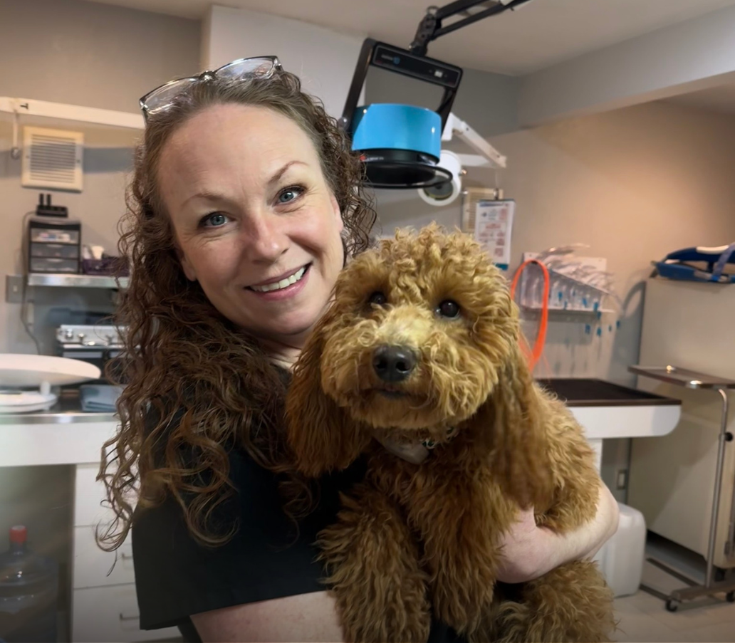 Dog and vet tech posing for a picture.
